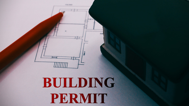 building permit written on paper with model house