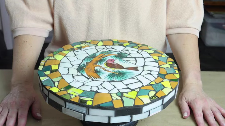 A stepping stone made from upcycled broken plates and dark grout.