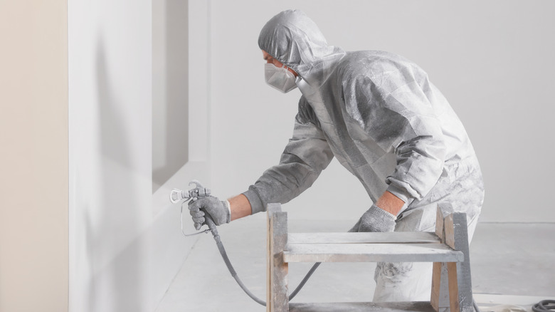 painting house wearing PPE