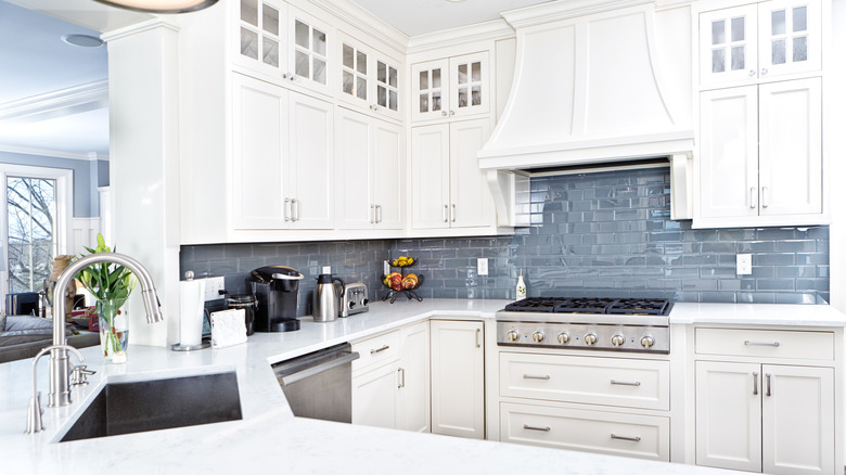 Beautiful kitchen with white cabinets and blue glass tiles