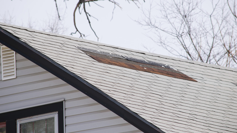 Missing and damaged shingles on a roof