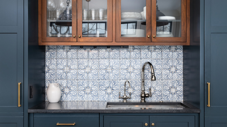 Kitchen with navy cabinets and patterned backsplash