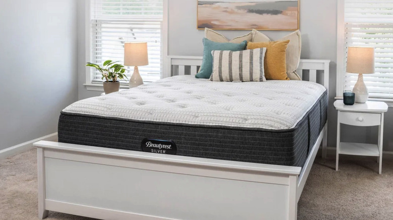 Beautyrest Silver matress on a white frame in a bedroom with 5 throw pillows
