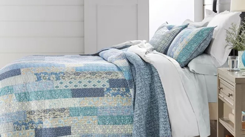 Macy's Charter Club quilted bedding in a blue patchwork pattern on a bed in a farmhouse-style bedroom