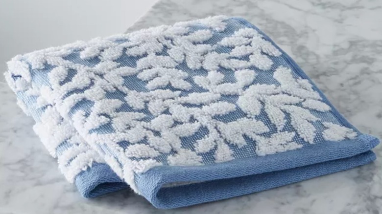 blue and white textured Macy's Charter Club washcloth folded on a marble countertop