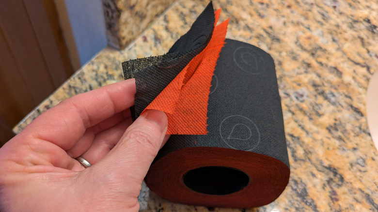 Black and red Renova toilet paper separated into four plies.