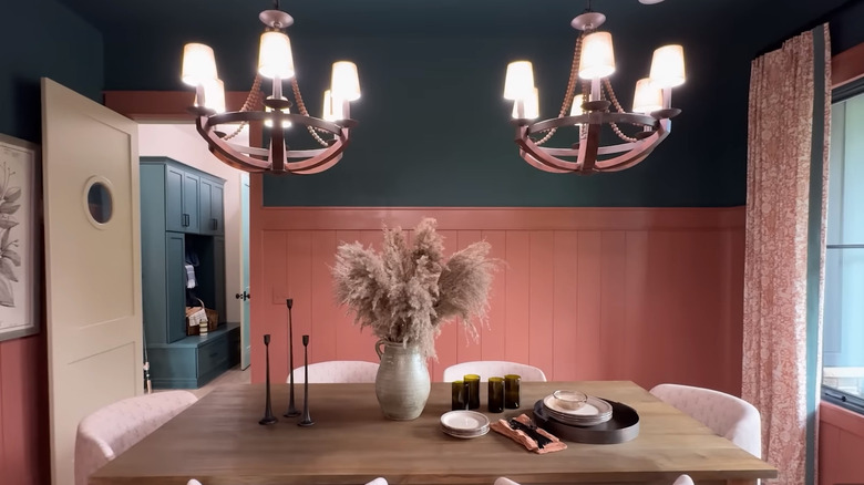 The dining room of HGTV's 2026 Dream Home with bright clay walls, muted lights, and detailed curtains