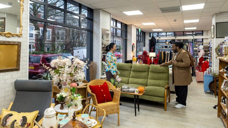 A man looks at a couch in a thrift store