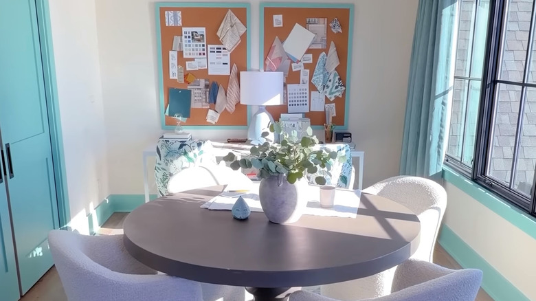The laundry lounge of HGTV's 2026 Dream Home with bright blue trimmings and details, white walls, and a comfortable and functional table in the center