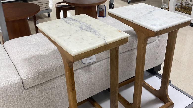 A TJ Maxx furniture section with a couch and two wooden tables with faux marble tops