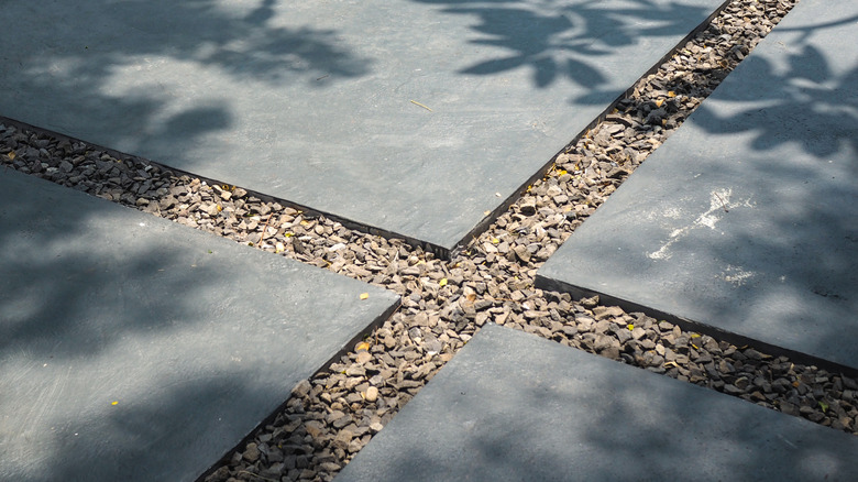 A standing area for trash cans made with pavers and gravel