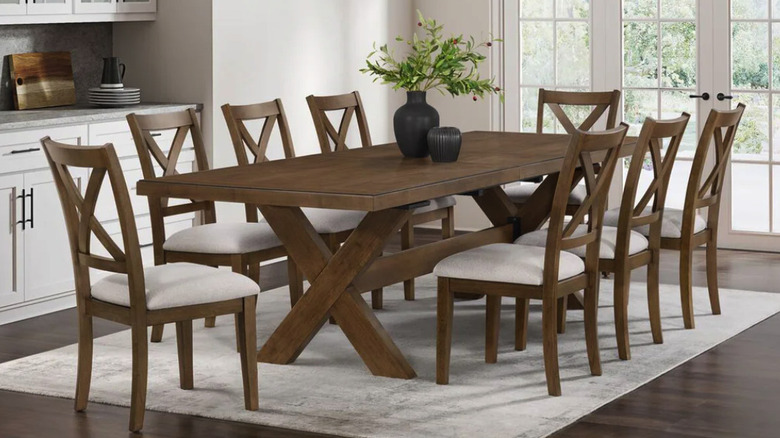 walnut colored table and eight wood chairs with white seat upholstery in a modern kitchen with natural light