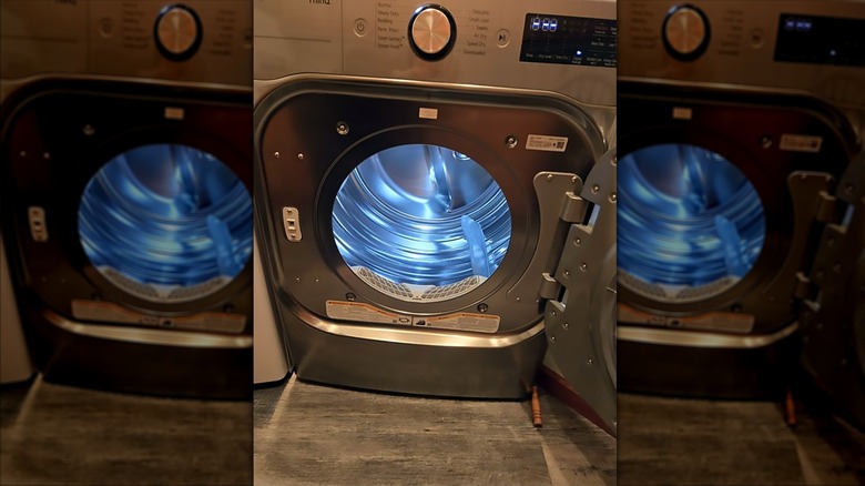 Dryer with drum door open and light on inside.