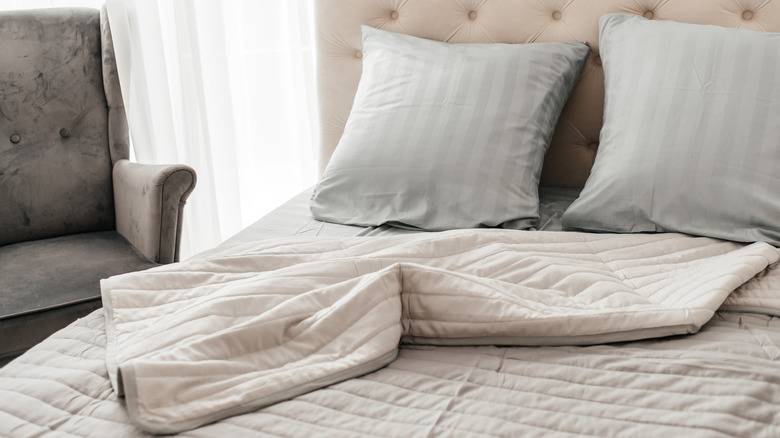 A neutral room with gray and beige striped bedding