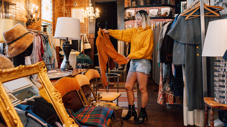 Woman shopping in a thrift store with no visible price tags