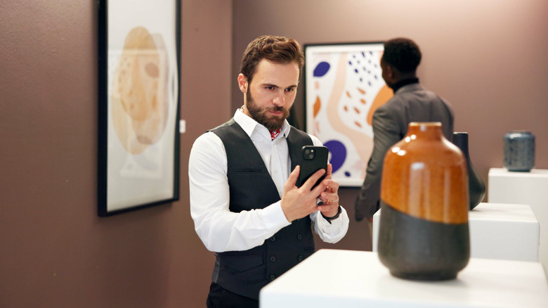 man photographing art in gallery