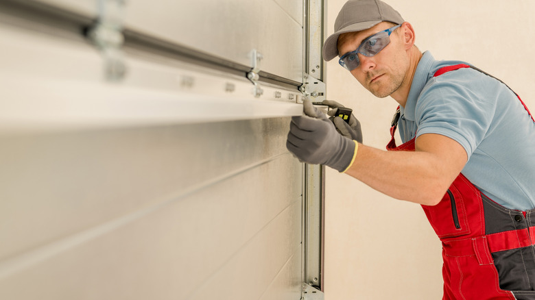Technician lining up components while installing a new garage door