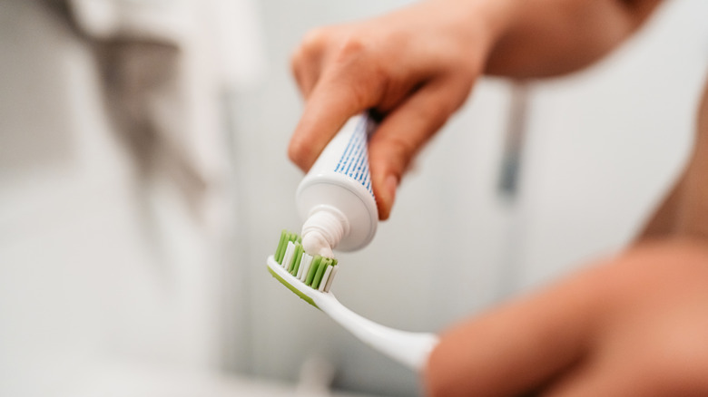 A man squeezes toothpaste onto a toothbrush
