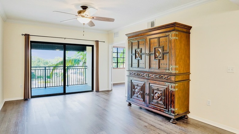 Spanish Colonial Revival armoire, with geometric carvings, on display in an empty room.