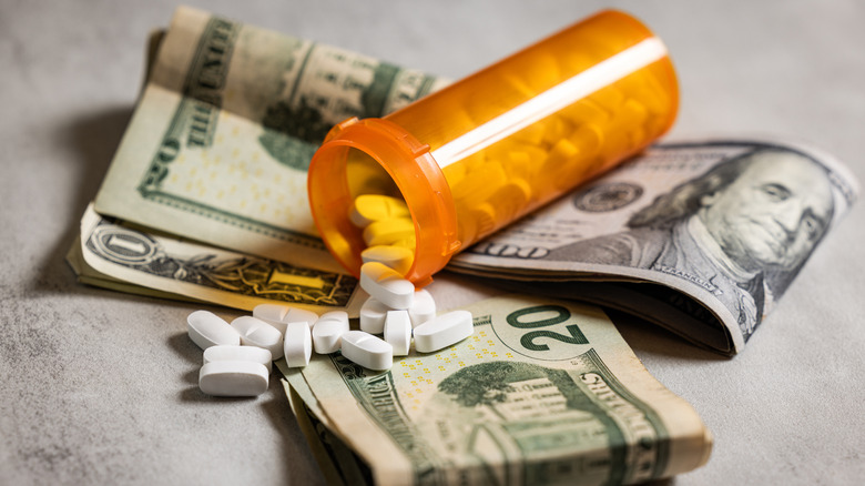 Prescription pill bottles laying on cash.