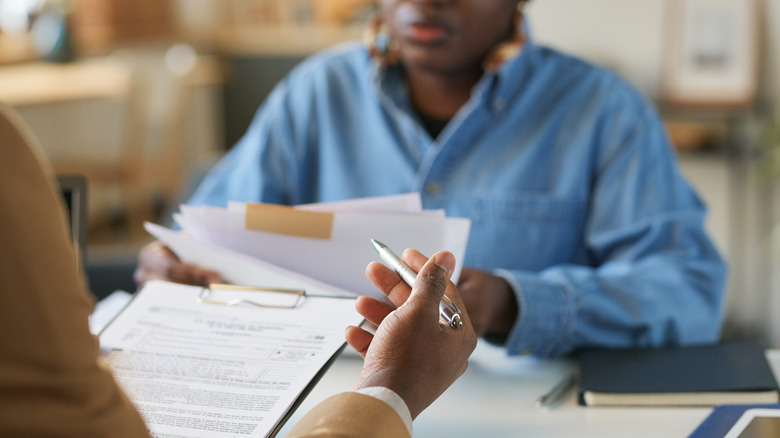 Two people sitting across from each other and examining legal documents