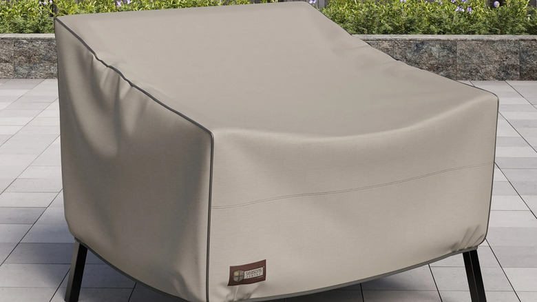Patio chair cover protects an outdoor chair sitting on a paver patio