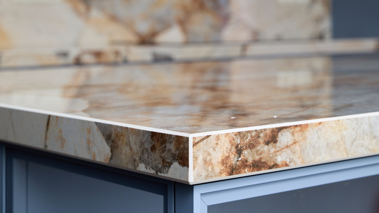 A stylish kitchen countertop with gorgeous natural marbling, with more of the same stone in the background