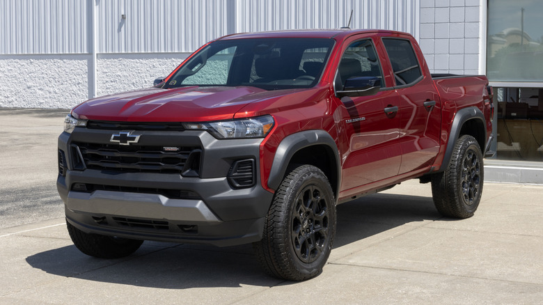 A red Chevrolet Colorado Trail Boss Midsize-Truck at a dealership