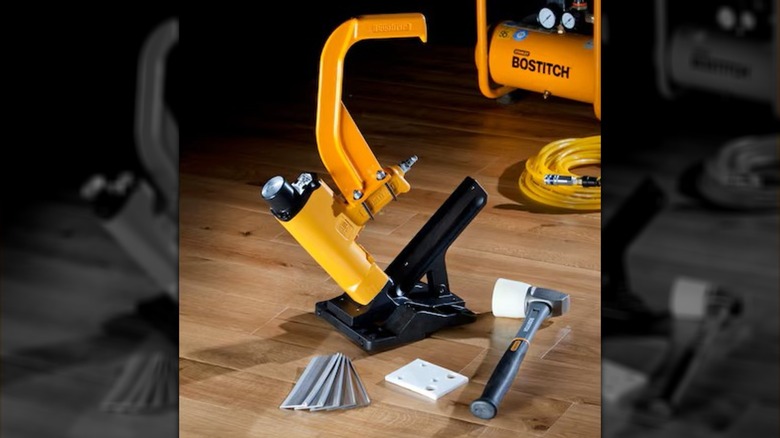 Bostitch Crown Flooring Pneumatic Stapler with accessories on top of wood flooring.