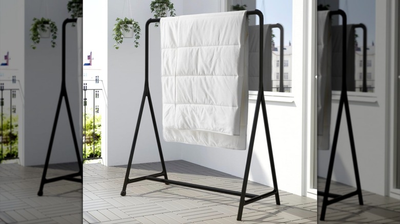 The IKEA TURBO Clothes rack holding a duvet insert on a patio