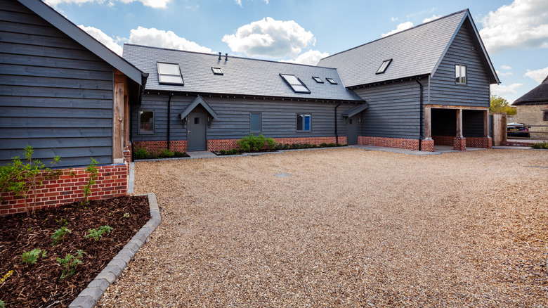 a modern home with a gravel driveway