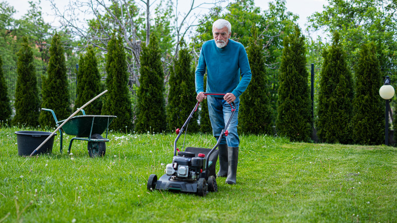 A man mowing the lawn in his backyard