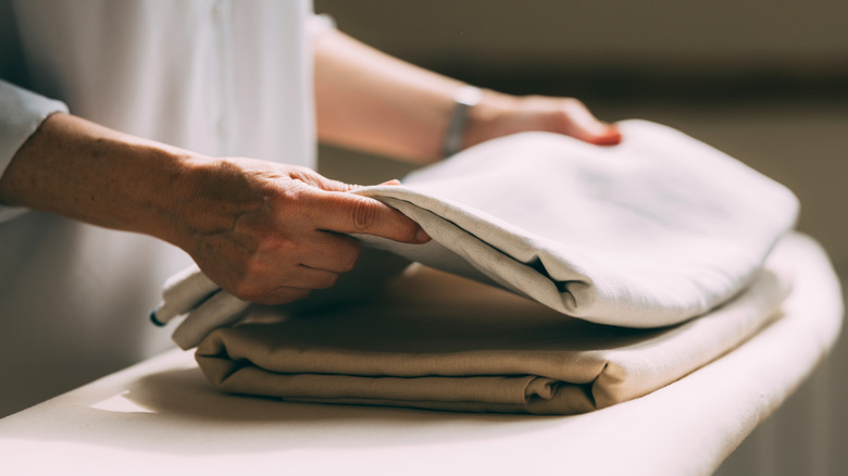 Someone folding bed sheets