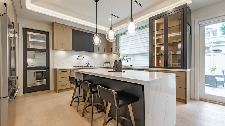 A contemporary, well-lit kitchen with various types of lighting