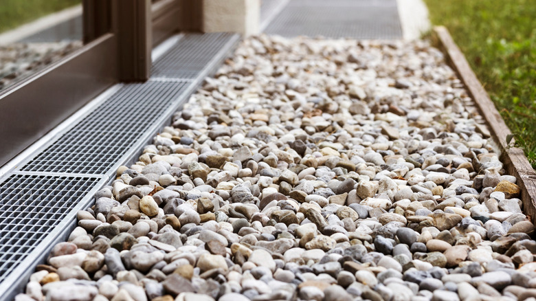 a French drain system with a downspout and gravel bed