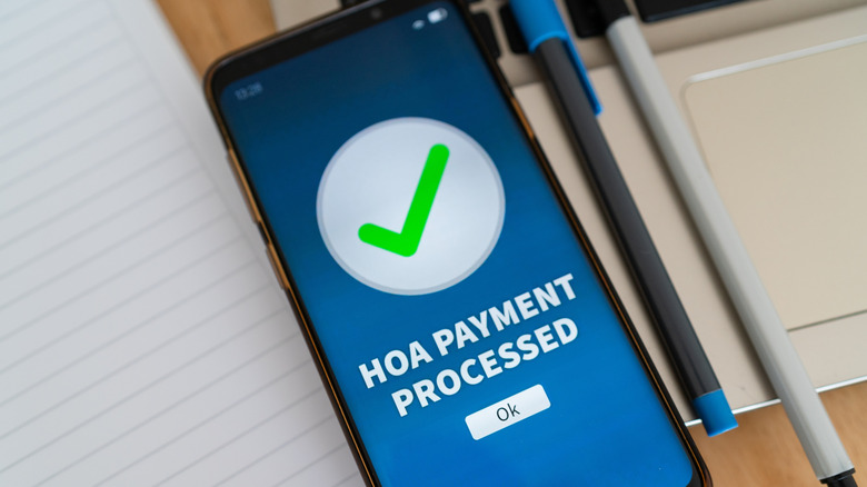 Mobile phone screen displaying 'HOA Payment Processed' notice.