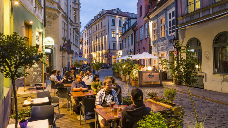 People dining on the street outside a restaurant in Riga, Latvia.