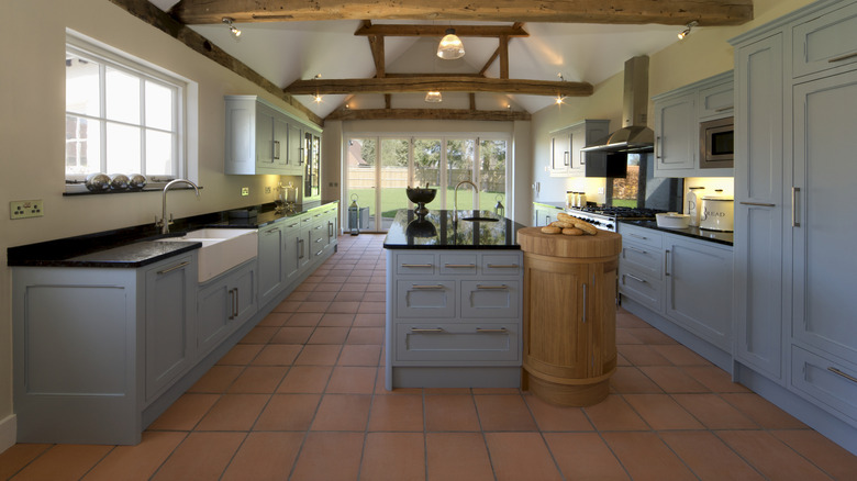 A large rustic kitchen with terracotta floors.