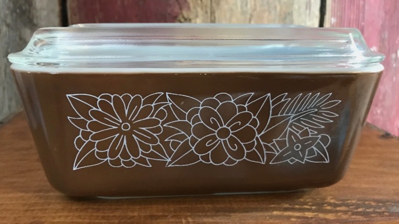 A brown Woodland Pyrex casserole dish with a glass lid